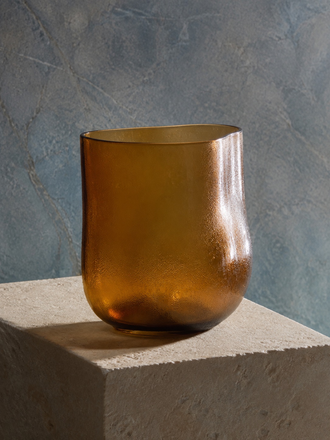 An amber vessel on stone, used as illustrative web and in-app creative